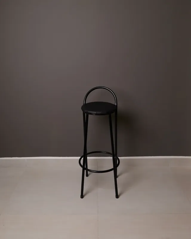 Banco preto de metal sobre fundo cinza-chumbo, no estúdio